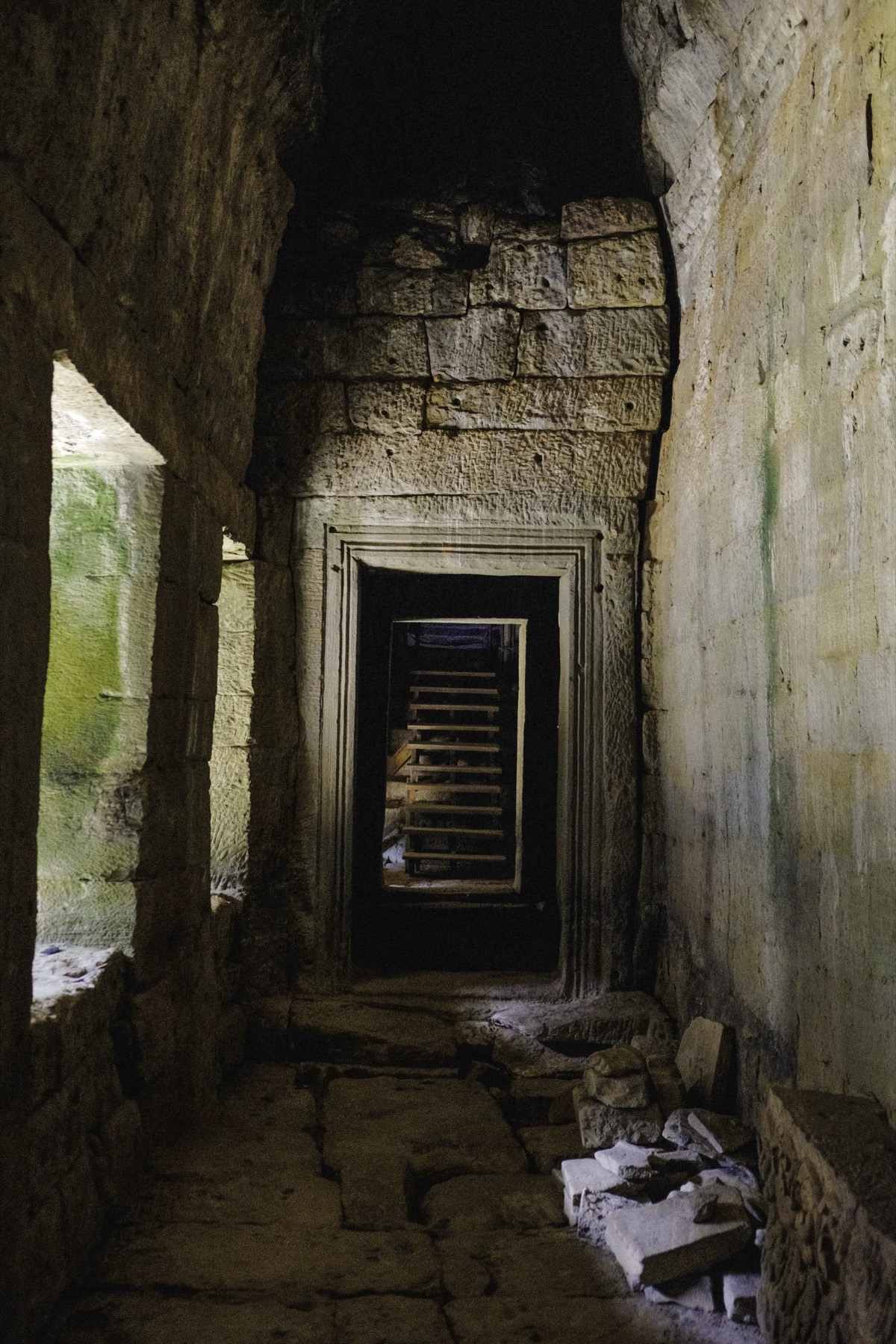 A doorway seen through a doorway in a temple corridor, scaffolding beyond.
